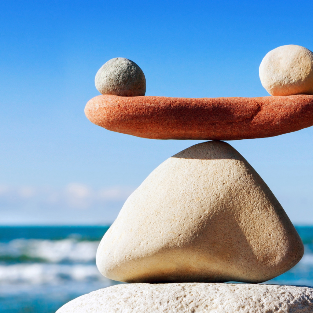 Rocks balancing against a blue sky.