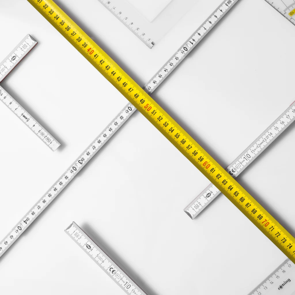 Measuring tapes arranged in different angles on white background.