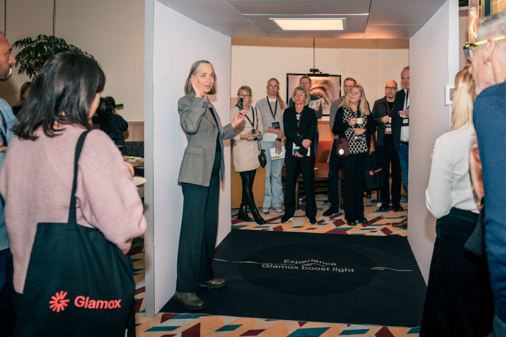 Woman presenting to a group at Glamox lighting design event.